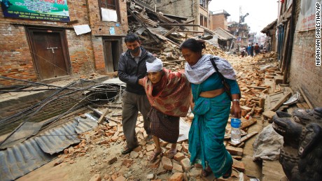 An elderly woman is helped to her home after being treated for her injuries in Bhaktapur, Nepal,  on Sunday, April 26. 