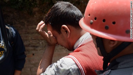 A Nepalese resident reacts as police retrieve the body of his relative Prasamsah, 14, during rescue efforts in Balaju in Kathmandu on April 27, 2015. International aid groups and governments intensified efforts to get rescuers and supplies into earthquake-hit Nepal on April 26, 2015, but severed communications and landslides in the Himalayan nation posed formidable challenges to the relief effort. As the death toll surpassed 2,000, the US together with several European and Asian nations sent emergency crews to reinforce those scrambling to find survivors in the devastated capital Kathmandu and in rural areas cut off by blocked roads and patchy phone networks. AFP PHOTO/PRAKASH SINGH        (Photo credit should read PRAKASH SINGH/AFP/Getty Images)