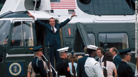 President Richard Nixon holds up V signs on the doorway of helicopter after leaving the White House following his resignation over the Watergate scandal on August 9, 1974. 