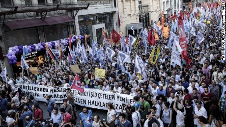 Protesters hold flags and a banner reading "Islamic state gangs will lose, our resisting people will win" during a demonstration on July 20, 2015 in Istanbul, after a suicide bombing in the Turkish town of Suruc near the border with Syria killed at least 31.