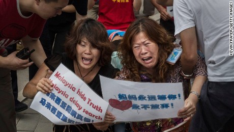 BEIJING, CHINA - AUGUST 07: Chinese relatives of passengers missing on Malaysian Airlines flight MH370 cry as they kneel in front of the media outside the Malaysian Embassy during a protest by relatives on August 7, 2015 in Beijing, China. France expanded its search for debris off Reunion Island Friday a day after Malaysia&#39;s prime minister announced that a piece of wing discovered last week is from Malaysia Airlines Flight MH 370 which vanished last year. Officials and experts from other countries including the United States and Australia have been more cautious, saying that more investigating needs to be done. (Photo by Kevin Frayer/Getty Images)