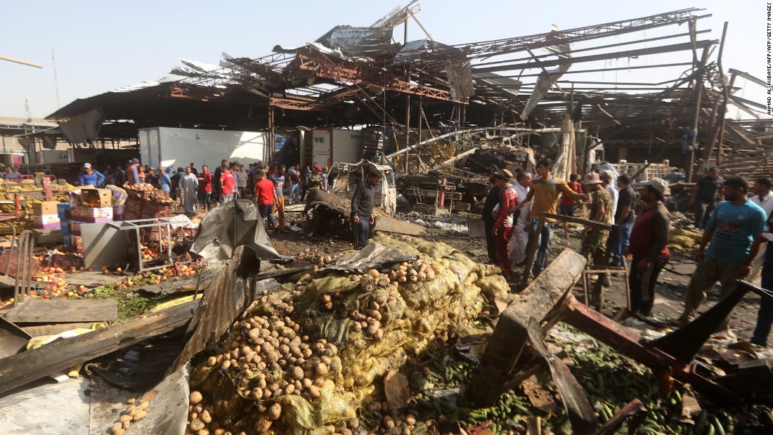 Iraqi men look at damage following a bomb explosion that targeted a vegetable market in Baghdad on Thursday, August 13. ISIS claimed responsibility for the attack. 