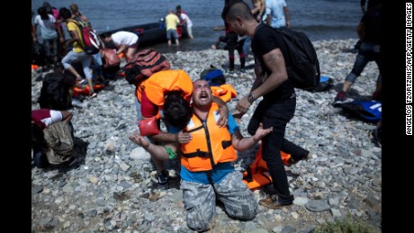 A refugee from Syria prays after arriving on the shores of the Greek island of Lesbos aboard an inflatable dinghy across the Aegean Sea from from Turkey on September 7, 2015. Greece sent troops and police reinforcements on September 6 to Lesbos after renewed clashes between police and migrants, the public broadcaster said, while Syrian refugees on the island were targeted with Molotov cocktail attacks. More than 230,000 people have landed on Greek shores this year and the numbers have soared in recent weeks as people seek to take advantage of the calm summer weather. AFP PHOTO / ANGELOS TZORTZINIS        (Photo credit should read ANGELOS TZORTZINIS/AFP/Getty Images)