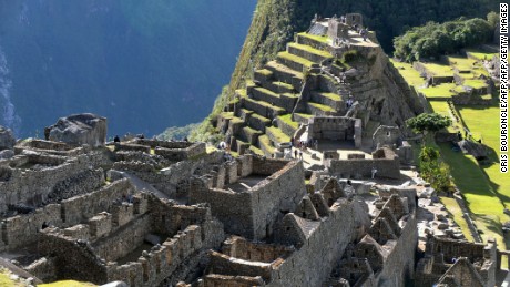 Tourists walk among the ruins of the Machu Picchu citadel, 130 km northwest of Cusco, Peru on July 6, 2011. The Inca compound is being prepared for the centennial commemoration of its discovery by American adventurer and archaeologist Hiram Bingham in 1911. Machu Picchu recognized as a World Wonder in 2007 sits at 2,350 meters above sea level in the heart of the Urubamba valley in southern Peru, 510 kilometers south of Lima. The complex which remained unknown to Spanish conquerors is now visited by up to 250,000 a year. AFP PHOTO/Cris BOURONCLE (Photo credit should read CRIS BOURONCLE/AFP/Getty Images)