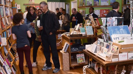 US President Barack Obama taks with manager Anna Thorn while shopping with daughters Malia and Sasha in Upshur Street Books during Small Business Saturday on November 28, 2015, in Washington, DC.