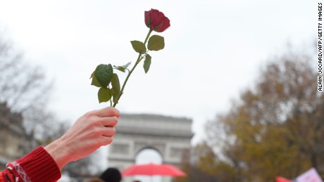 An activist holds up a rose as other activists gather to form a giant red line during a demonstration near the Arc de Triomphe at the Avenue de la Grande armee boulevard in Paris on December 12, 2015, as a proposed 195-nation accord to curb emissions of the heat-trapping gases that threaten to wreak havoc on Earth&#39;s climate system is to be presented at the United Nations conference on climate change COP21 in Le Bourget, on the outskirts of Paris.  AFP PHOTO / ALAIN JOCARD / AFP / ALAIN JOCARD        (Photo credit should read ALAIN JOCARD/AFP/Getty Images)