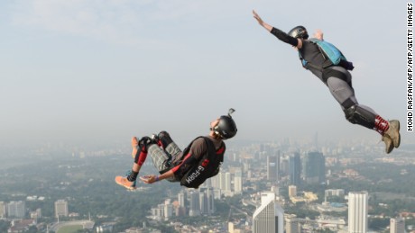 Base jumpers Annette O&#39;Neil (top) and Bret Kistler (bottom) of the US leap from the 300-metre high Open Deck of Malaysia&#39;s landmark Kuala Lumpur Tower during the International Tower Jump in Kuala Lumpur on September 27, 2014. Some 100 professional base jumpers from 20 countries are taking part in the annual event. AFP PHOTO / MOHD RASFAN        (Photo credit should read MOHD RASFAN/AFP/Getty Images)
