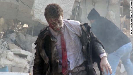 A man emerges from the wreckage of a courthouse in rebel-held Idlib, Syria after it was hit by airstrikes in December 2015.