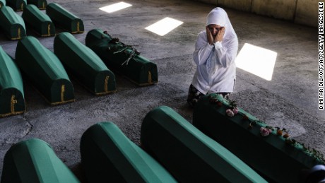 A Bosnian woman mourns next to the coffin of a relative among 136 newly identified victims of the 1995 Srebrenica massacre at the Potocari Memorial Center near the eastern Bosnian town of Srebrenica, on July 10, 2015, where the bodies found in mass grave sites will be reburied on the 20th anniversary of the massacre. Nearly 8,000 men and boys from the enclave were captured and systematically killed by Bosnian Serb forces in the days following the fall of Srebrenica on July 11, 1995. AFP PHOTO / DIMITAR DILKOFF        (Photo credit should read DIMITAR DILKOFF/AFP/Getty Images)
