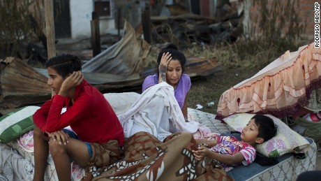 A family wakes up after sleeping outside their collapsed home which was destroyed by the earthquake in Manta, Ecuador April 19.