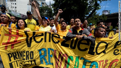 Members of the Venezuelan opposition shout slogans during a march to demand electoral power to activate the recall referendum against President Nicolas Maduro, in Caracas on July 27, 2016.
Venezuela's opposition called protests Wednesday to demand electoral authorities allow a referendum on removing Maduro from power, a day after the government moved to outlaw the coalition. / AFP / FEDERICO PARRA        (Photo credit should read FEDERICO PARRA/AFP/Getty Images)
