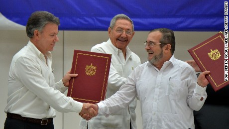 Colombia's President Juan Manuel Santos (L) and Timoleon Jimenez, aka "Timochenko" (R), head of the FARC leftist guerrilla, shake hands accompanied by Cuban President Raul Castro (C) during the signing of the peace agreement in Havana on June 23, 2016.
Colombia's government and the FARC guerrilla force signed a definitive ceasefire Thursday, taking one of the last crucial steps toward ending Latin America's longest civil war. / AFP / ADALBERTO ROQUE        (Photo credit should read ADALBERTO ROQUE/AFP/Getty Images)