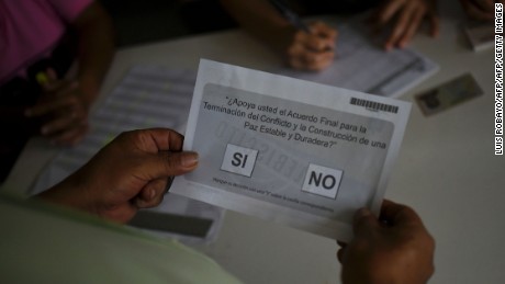 A Colombian citizen receives the ballot before voting in a referendum on whether to ratify a historic peace accord to end Colombia's 52-year war between the state and the communist FARC rebels, in Cali, Colombia, on October 2, 2016.
The accord will effectively end what is seen as the last major armed conflict in the Western Hemisphere. The war has killed hundreds of thousands of people and displaced millions. / AFP PHOTO / LUIS ROBAYOLUIS ROBAYO/AFP/Getty Images