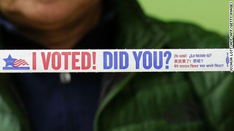 Angel Robles poses for a portrait with his "I Voted! Did You?" risk band after voting early at a polling station inside Truman College on October 31, 2016 in Chicago, Illinois. / AFP / Joshua Lott        (Photo credit should read JOSHUA LOTT/AFP/Getty Images)
