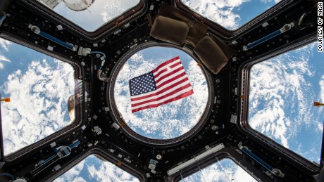 Imagen Kjell Lindgren difundida en redes sociales de la bandera estadounidense flotando en el módulo Cupola. 