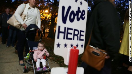 ALEXANDRIA, VA - NOVEMBER 08:  Local resident Kendra Isaacson (L) waits in-line with her 11-month-old daughter Katie Isaacson for casting her ballot outside a polling place on Election Day November 8, 2016 in Alexandria, Virginia. Americans across the nation are picking their choice for the next president of the United States.  (Photo by Alex Wong/Getty Images)