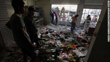 Employees of a looted local supermarket inspect the damages the business suffered in La Fria, Tachira state, Venezuela on December 19, 2016. 
A jet load of new currency finally arrived in Venezuela on December 18 after its delayed arrival sparked protests and looting that jolted President Nicolas Maduro's unpopular government. / AFP / GEORGE CASTELLANOS        (Photo credit should read GEORGE CASTELLANOS/AFP/Getty Images)