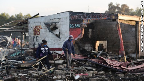 People search amid the debris left by a huge blast that occured in a fireworks market in Mexico City, on December 20, 2016 killing at least 26 people and injuring scores.
The conflagration, in the suburb of Tultepec, set off a quickfire series of multicolored blasts and a vast amount of smoke that hung over Mexico City.  / AFP / RONALDO SCHEMIDT        (Photo credit should read RONALDO SCHEMIDT/AFP/Getty Images)