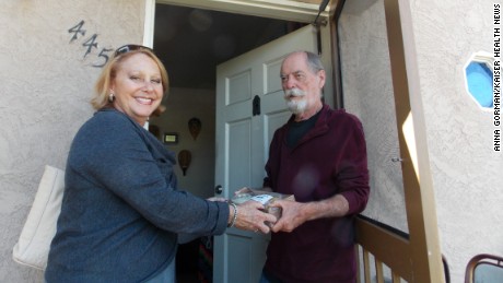 Debbie Case, CEO of the Meals on Wheels San Diego County, delivers lunch and dinner to 75-year-old David Kelly. Kelly lost his sight about two years ago and reluctantly gave up cooking. (Anna Gorman/KHN)