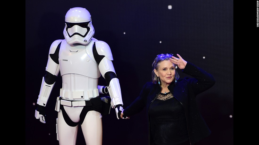 Fisher salutes as she poses with a storm trooper at the European premiere of &quot;Star Wars: The Force Awakens&quot; in central London on December 16, 2015.