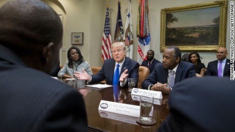 President Donald Trump holds an African American History Month listening session attended by nominee to lead the Department of Housing and Urban Development (HUD) Ben Carson (R), Director of Communications for the Office of Public Liaison Omarosa Manigault (L) and other officials in the Roosevelt Room of the White House on February 1, 2017 in Washington, DC.