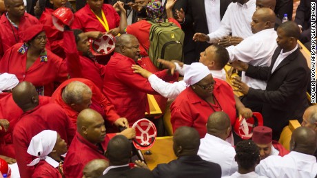 Members of the Economic Freedom Fighters, wearing red uniforms, clash with security forces during the South African President&#39;s State of the Nation address in Cape Town on February 12, 2015. 