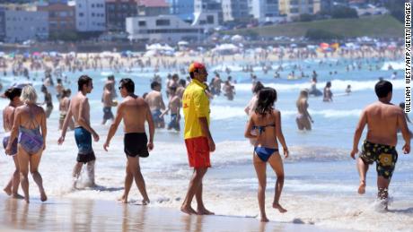 A surf lifesaver supervises swimmers at Sydney's Bondi Beach on February 11, 2017. Much of Australia is experiencing a heatwave with the New South Wales weather bureau is predicting that February 11 could become the hottest February day on record for the state. 