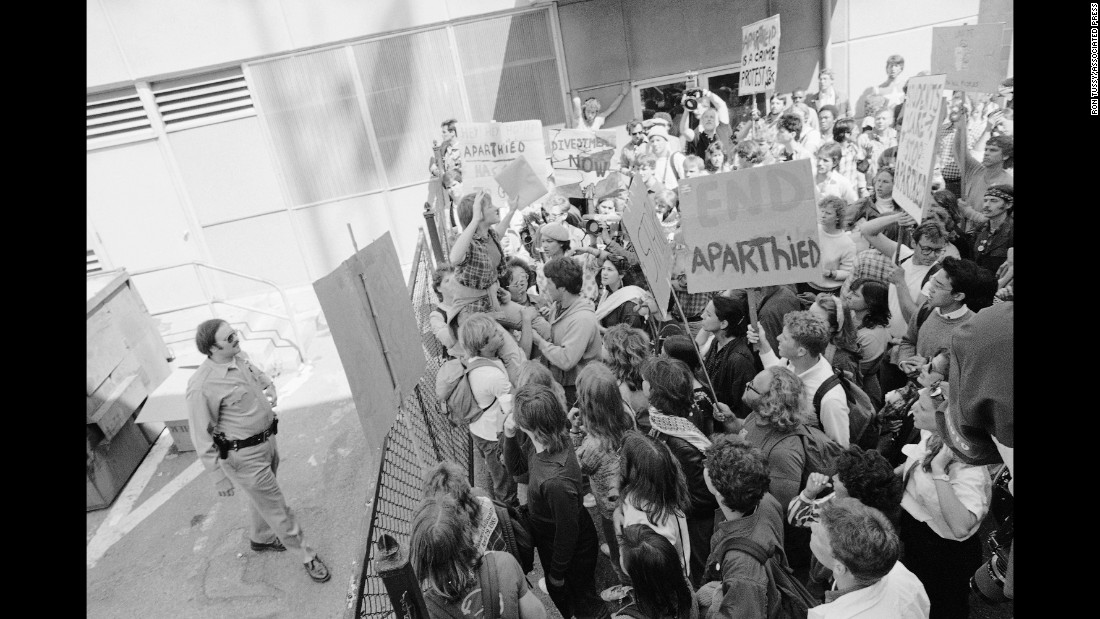 A group of anti-apartheid demonstrators find themselves blocked off behind the municipal building in Berkeley, California on April 18, 1985, after marching from campus to a courthouse where 20 demonstrators were awaiting arraignment. The protesters became trapped in an alley after police closed a gate on them. 