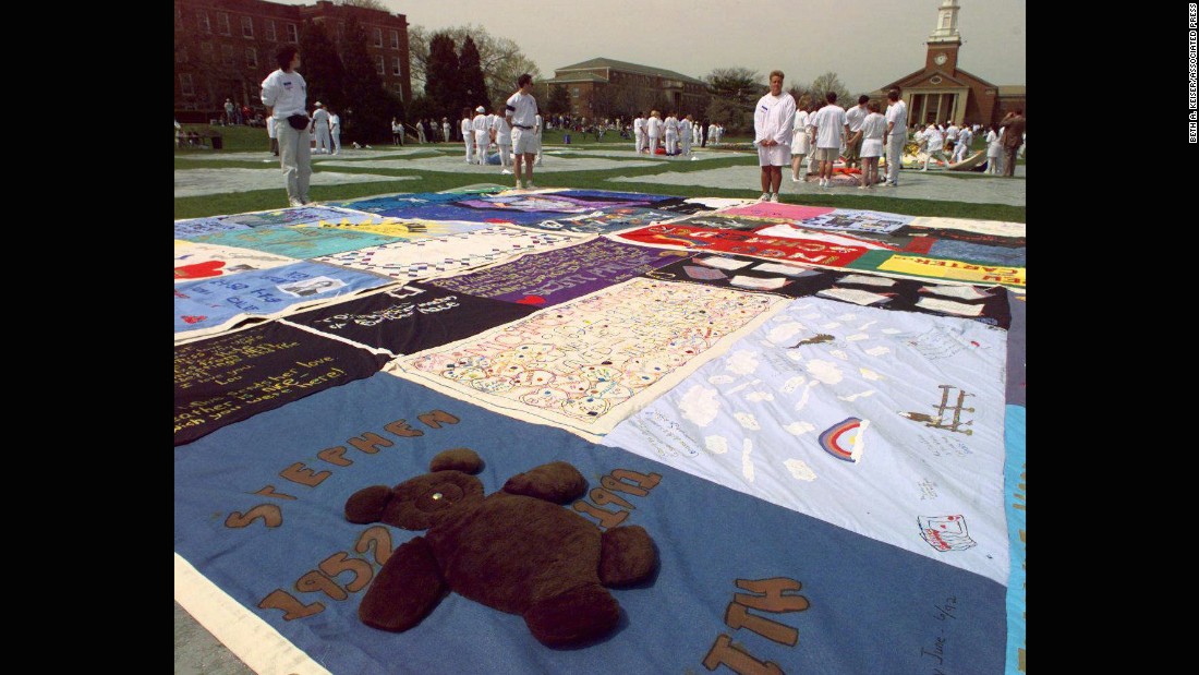 A teddy bear adorns one more than 400 panels of the AIDS Memorial Quilt as volunteers stand by silently during a 1996 ceremony at &lt;strong&gt;Elmhurst College&lt;/strong&gt; in Elmhurst, Ilinois.  