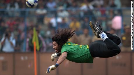 Former Colombian goolkeeper Rene Higuita kicks the ball to save a goal during an exhibition match between the Brazilian Masters and Indian All Stars in Kolkata on December 8, 2012. The Brazilian team won the match by 3-1. AFP PHOTO/ Dibyangshu SARKAR        (Photo credit should read DIBYANGSHU SARKAR/AFP/Getty Images)