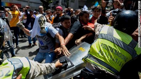 Opposition activists scuffle with riot police during a protest against President Nicolas Maduro's government in Caracas on April 4, 2017. 
Activists clashed with police in Venezuela Tuesday as the opposition mobilized against moves to tighten President Nicolas Maduro's grip on power. Protesters hurled stones at riot police who fired tear gas as they blocked the demonstrators from advancing through central Caracas, where pro-government activists were also planning to march. / AFP PHOTO / FEDERICO PARRA        (Photo credit should read FEDERICO PARRA/AFP/Getty Images)