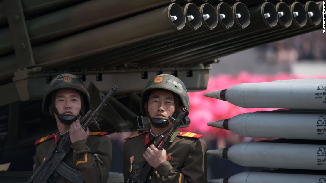 Members of the Korean People&#39;s Army ride on mobile missile launchers.