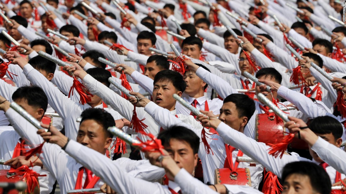 North Korean men beat drums as they parade across the square. 
