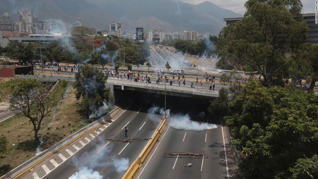 Clouds of tear gas spread across a highway in Caracas during clashes on Monday, April 10.