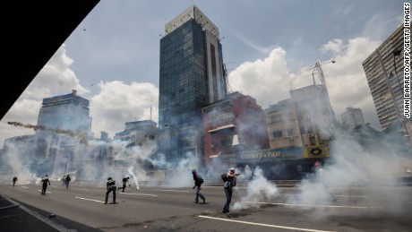 Demonstrators clash with the police during a rally against Venezuelan President Nicolas Maduro, in Caracas on April 19, 2017.
Venezuela braced for rival demonstrations Wednesday for and against President Nicolas Maduro, whose push to tighten his grip on power has triggered waves of deadly unrest that have escalated the country&#39;s political and economic crisis. / AFP PHOTO / Juan BARRETO        (Photo credit should read JUAN BARRETO/AFP/Getty Images)