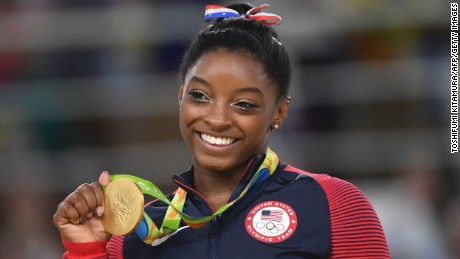 US gymnast Simone Biles celebrates on the podium of the women's floor event final of the Artistic Gymnastics at the Olympic Arena during the Rio 2016 Olympic Games in Rio de Janeiro on August 16, 2016.