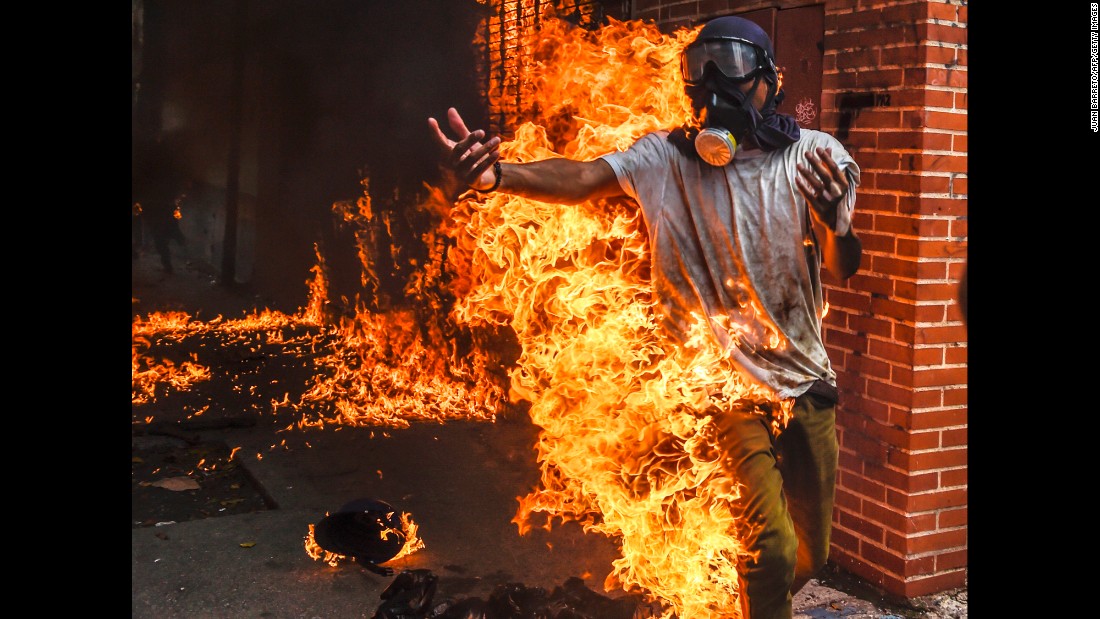 A demonstrator catches fire during protests in Caracas on May 3. It happened as protesters clashed with police and the gas tank of a police motorcycle exploded. Other photos from the scene showed the man being attended for burns to his body.