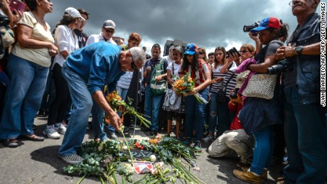 People lay  flowers after a mass during a protest against the death -on yesterday's protest- of Miguel Castillo, in Caracas on May 11, 2017.
Daily clashes between demonstrators -who blame elected President Nicolas Maduro for an economic crisis that has caused food shortage- and security forces have left 38 people dead since April 1, prosecutors say. Protesters demand early elections, accusing Maduro of repressing protesters and trying to install a dictatorship.
 / AFP PHOTO / JUAN BARRETO        (Photo credit should read JUAN BARRETO/AFP/Getty Images)