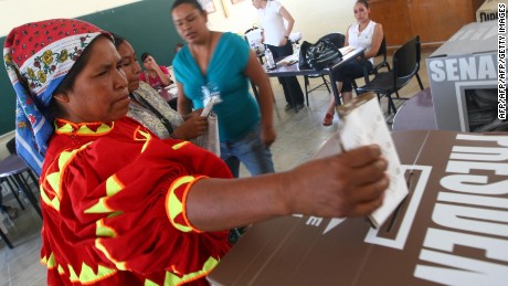 A Taraumara indigenous woman in traditional clothes casts her vote at a polling station in the northern border city of Ciudad Juarez, Mexico during elections on July 1, 2012. Voters, exhausted by violence, seem prepared to bring the Institutional Revolutionary Party (PRI), which ran the country for seven decades, back to office. Mexican presidents are elected by simple majority for six-year terms and are banned from running for reelection.  AFP PHOTO/JESUS ALCAZAR        (Photo credit should read Jesus Alcazar/AFP/GettyImages)