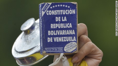 An activist shows the Venezuelan constitution during a march against President Nicolas Maduro in San Cristobal, Tachira State, Venezuela, on May 20, 2017.
Venezuelan protesters and supporters of embattled President Nicolas Maduro take to the streets Saturday as a deadly political crisis plays out in a divided country on the verge of paralysis. / AFP PHOTO / LUIS ROBAYO        (Photo credit should read LUIS ROBAYO/AFP/Getty Images)