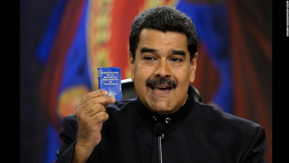 Maduro holds up a copy of the Venezuelan constitution during a news conference at the presidential palace in Caracas on June 22. Maduro has called for changes to the constitution amid the unrest.