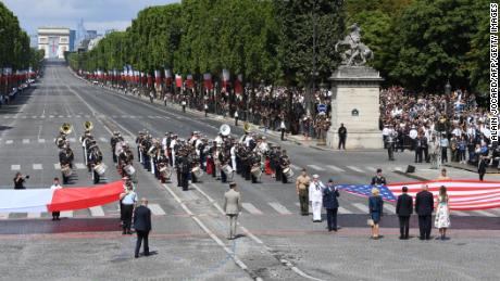 (RtoL) US First Lady Melania Trump, US President Donald Trump, French President Emmanuel Macron and his wife Brigitte Macron, walk towards the US national flag held by soldiers, as a French joint-army brass band performs, at the end of the annual Bastille Day military parade on the Champs-Elysees avenue in Paris on July 14, 2017.  
The parade on Paris&#39;s Champs-Elysees will commemorate the centenary of the US entering WWI and will feature horses, helicopters, planes and troops. / AFP PHOTO / ALAIN JOCARD        (Photo credit should read ALAIN JOCARD/AFP/Getty Images)