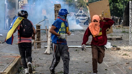 Masked opposition demonstrators take part in clashes with riot police ensuing an anti-government protest in Caracas, on July 26, 2017.
Venezuelans blocked off deserted streets Wednesday as a 48-hour opposition-led general strike aimed at thwarting embattled President Nicolas Maduro&#39;s controversial plans to rewrite the country&#39;s constitution got underway. / AFP PHOTO / FEDERICO PARRA        (Photo credit should read FEDERICO PARRA/AFP/Getty Images)