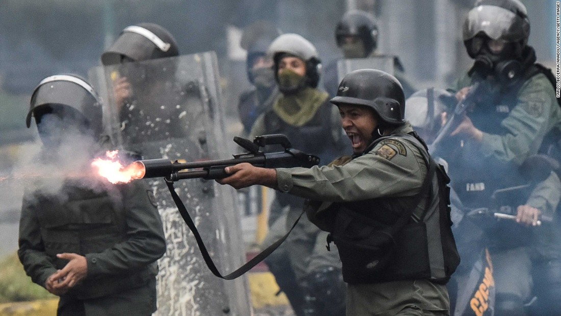 A member of the National Guard fires at protesters during clashes in Caracas on Friday, July 28. 