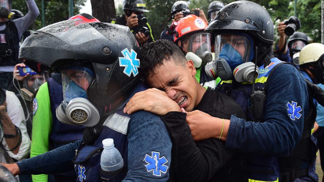A wounded anti-government demonstrator is helped by medics during clashes with police in Caracas on July 30.