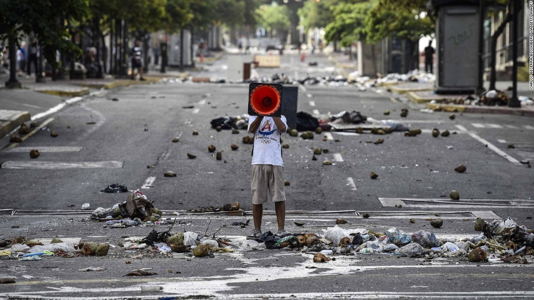 A demonstrator shouts slogans through a traffic cone during an anti-government protest in Caracas on July 30.
