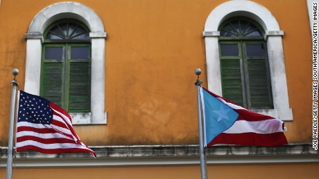 SAN JUAN, PUERTO RICO - JUNE 30:  An American flag and Puerto Rican flag fly next to each other in Old San Juan a day after the Puerto Rican Governor Alejandro Garcia Padilla gave a televised speech regarding the governments $72 billion debt on June 30, 2015 in San Juan, Puerto Rico.  The Governor said in his speech that the people will have to sacrifice and share in the responsibilities for pulling the island out of debt.  (Photo by Joe Raedle/Getty Images)