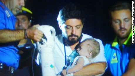 This image grab shows Italian emergency workers rescuing a baby after an earthquake hit the popular Italian tourist island of Ischia, off the coast of Naples, causing several buildings to collapse on August 21, 2017. 
A magnitude-4.0 earthquake struck the Italian holiday island of Ischia, causing destruction that left two people dead at peak tourist season, authorities said, as rescue workers struggled early to free two children from the rubble. / AFP PHOTO / Gaetano Di MEGLIO        (Photo credit should read GAETANO DI MEGLIO/AFP/Getty Images)