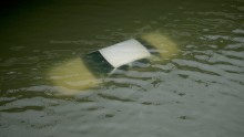 A car is submerged by floodwaters on a freeway near downtown Houston.