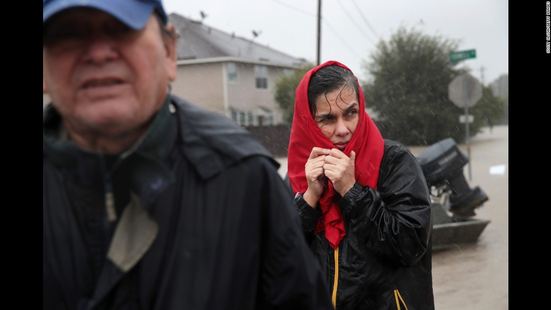 People make their way out of a flooded neighborhood in Houston on August 28.